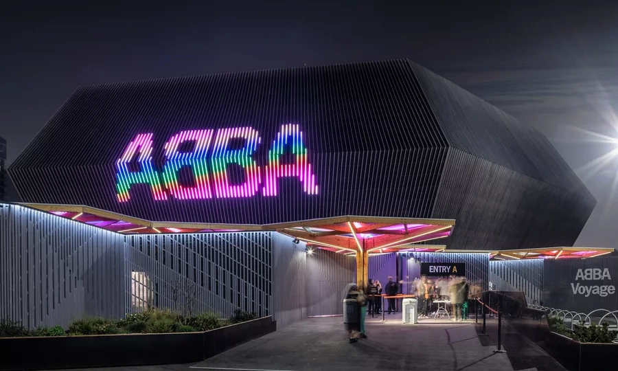 ABBA Arena entrance at night with the illuminated multicoloured ABBA sign