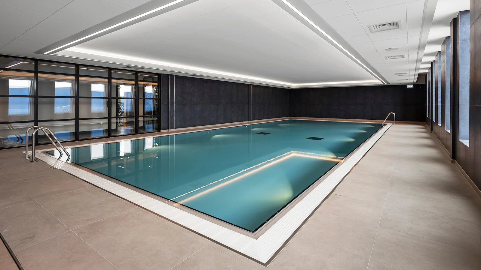 The indoor pool at Ipswich Town FC’s training complex, with perimeter glazing and linear ceiling lighting.
