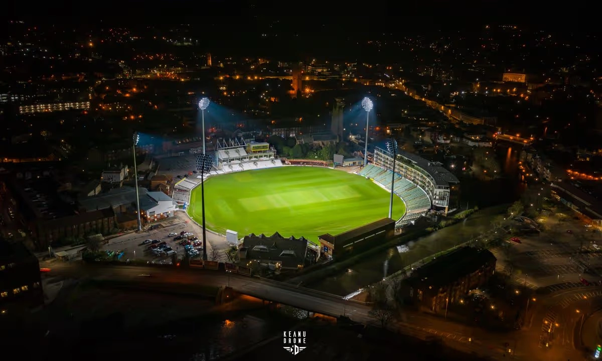 Night-time aerial of Somerset County Cricket Club’s ground in Taunton illuminated by its floodlights